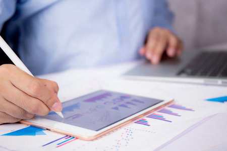 Businessman planning about graph and chart of investment with report for finance on tablet computer...