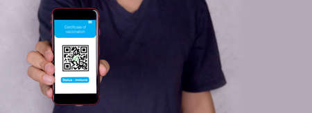 Certificate of vaccination  , man holding smartphone showing vaccinated, prevention epidemic, health and antibody, one person, male in face mask hold mobile smart phone show identity.の写真素材