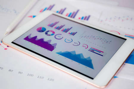 Report graph and chart of investment with finance on tablet computer on desk, datum of stock and growth, planning and statistic with economic, no people, digital marketing, business concept.の写真素材