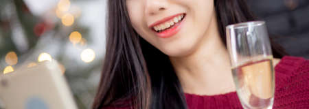 Young asian woman selfie video call online with friends and show glass in Christmas day on phone at...