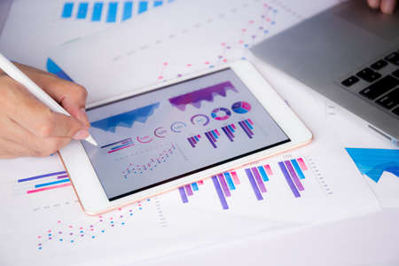 Businessman planning about graph and chart of investment with report for finance on tablet computer...