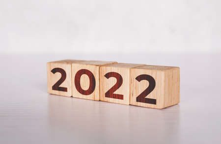 Cube wooden block with text year 2022, beginning and trend, calendar and time, determination target and planning for achievement, motivation and aspirations and improvement, business concepts.の写真素材