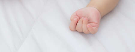 Portrait of asian little baby girl sleeping on bed in the bedroom at home, newborn napping with cozy and relax, infant innocence in bedtime, happy toddler cute, growth of child and emotion, indoors.の写真素材