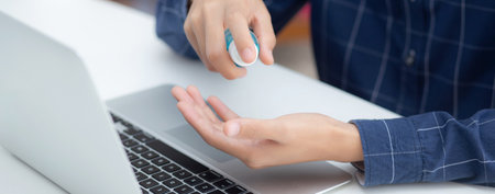 Hand of man work from home with alcohol gel or sanitizer for cleaning hand and protect coronavirus...