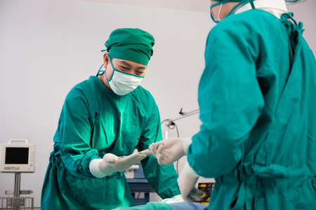 Doctor sending instrument with surgeon with rescue and  save patient in the operation room at...