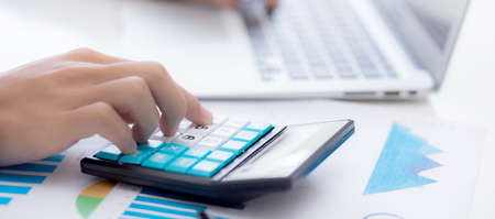 Hand of young asian business man working using calculator for planning accountant, graph for finance...