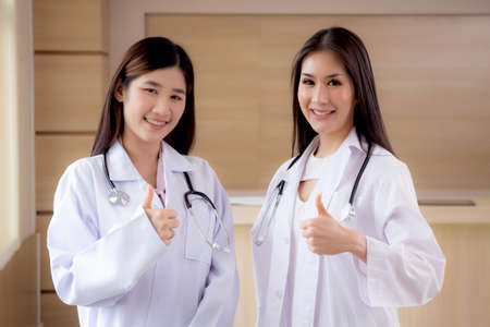 Portrait group of team doctors standing and showing thumbs up with confident and success at hospital together, hands of teamwork physician and friendly, two people, medical and health concept.の写真素材