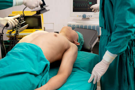 Doctor and surgeon CPR machine pump heart of patient emergency on chest for rescue in the operation...