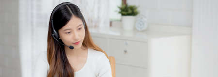 Young asian woman wearing headphone study online with e-learning on desk, girl wearing headset learning to internet with laptop computer at home, new normal, distance education and training.の写真素材