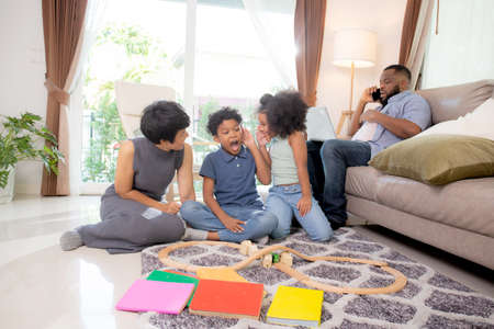 Happy family father and mother and children doing activity playing toy railway with fun in the living room, child relax and development with education, bonding and relation, diversity with ethnicity.の写真素材