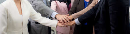 Group of business team harmony with man and woman joining hands stack together in enterprise for victory and success, teamwork of partnership with meeting and cheering, deal and agreement.の写真素材