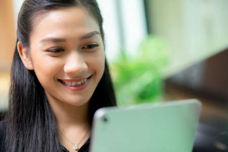 Young asian businesswoman using tablet computer working at office, woman or employee looking tablet with confident, businesspeople working online, one person, business and communication concept.の写真素材