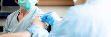 Doctor preparing vaccination of senior, infection and immunization, medical concept.の写真素材