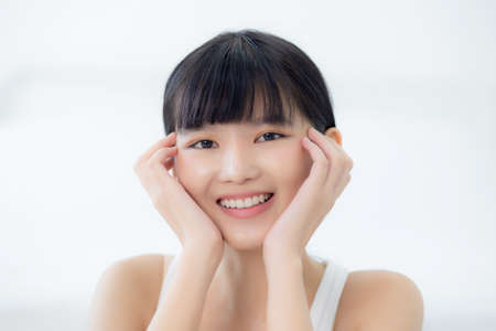 Beautiful young asian woman makeup of cosmetic, girl hand touch cheek on face and smiling attractive, facial of beauty perfect skincare with wellness and wrinkle, skin care and health concept.の写真素材
