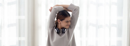Beautiful young woman waking up in the morning and stretching sitting on bed in the bedroom at home, girl is a cozy with fresh happiness and smile, wellbeing and health concept.の写真素材