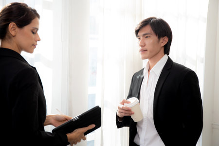 Young manager talking with secretary about report marketing on digital tablet for planning at office, executive discussion with employee woman together, leadership and employee, business concept.の写真素材