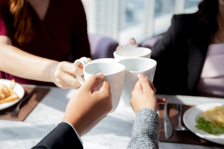 Closeup hands of team young business people in party celebrate success holding glass beverages cheer...