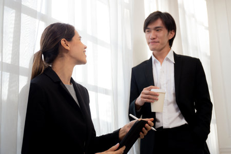 Young manager talking with secretary about report marketing on digital tablet for planning at office, executive discussion with employee woman together, leadership and employee, business concept.の写真素材