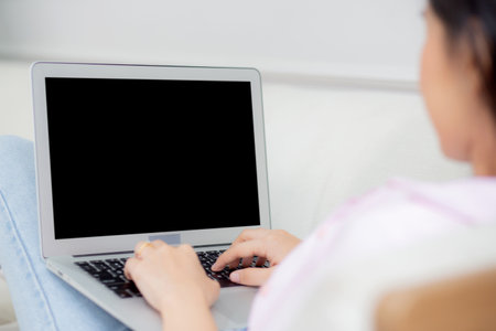 Young asian woman work from home with laptop computer blank screen mockup, freelance is female using notebook with display empty, girl typing keyboard, business and communication concept.の写真素材