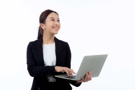 Portrait young asian business woman standing work on laptop computer to internet online isolated on white background, businesswoman in suit confident and using notebook, marketing and communication.の写真素材