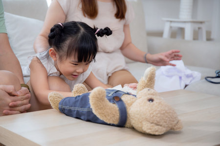 Happiness asian family father and mother and daughter sitting on sofa in living room at home, happy dad and mom and kid sitting and relax with comfortable on couch together, lifestyles concept.の写真素材