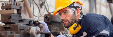 Young caucasian engineer man operating lathe machine for preparing production at factory industrial, technician or labor maintenance machinery at workplace, metalworker working, industry concept.の写真素材