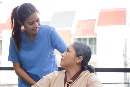 Caregiver asian woman care elderly sitting on wheelchair, consoling for encourage in garden at hospital, senior therapy and rehabilitation with doctor for rehab and treatment, insurance and medical.の写真素材