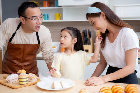 Happy family with father, mother and daughter in kitchen eating sandwich for healthy together at home, happiness mom, dad and child with bonding and relation, lifestyles and nutrition concept.の写真素材