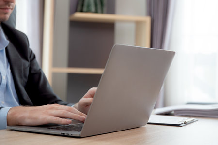 Hands young caucasian businessman using laptop computer planning for success in modern office,...