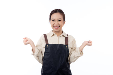 Portrait young asian barista woman wearing apron standing and smile isolated white background, waitress or entrepreneur cheerful, small business or startup, waiter of cafe or coffee shop.の写真素材