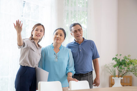 Happy couple elderly looking new home while agent real estate explaining and visit, realtor talking customer about rental housing, banking and mortgage officers, business and insurance concept.の写真素材