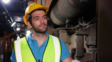 Young caucasian engineer man maintenance and repair train diesel engine in station, engineer walking...