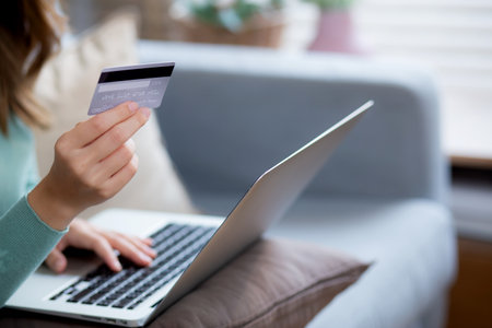 Young asian woman sitting on sofa using laptop computer shopping online with credit card buying to internet, female payment with business on couch, purchase and payment, business and lifestyles.の写真素材