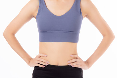 Closeup waist and abdomen of asian woman beautiful with slim isolated on white background, closeup belly with workout and exercise for slim and weightloss with diet, health and wellbeing concept.の写真素材