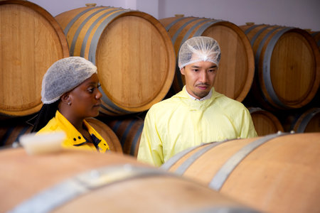 Winemaker team checking and examining producing wine at winery in factory, inspector checking...