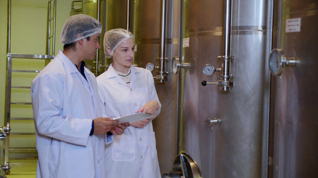 Winemaker team checking and examining producing wine at winery in factory, inspector checking...