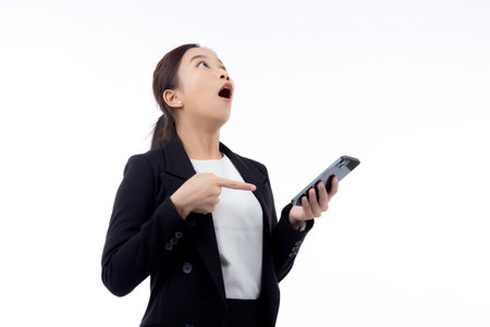 Portrait young asian businesswoman in suit gesture surprised while looking smartphone isolated white background, business woman excited with amazed while looking smart phone, business concept.の写真素材