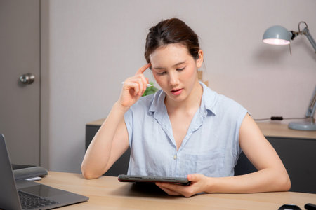 Young caucasian business woman working with tablet while thinking for planning financial on desk in modern home office, businesswoman planning and thoughtful about working, business concept.の写真素材