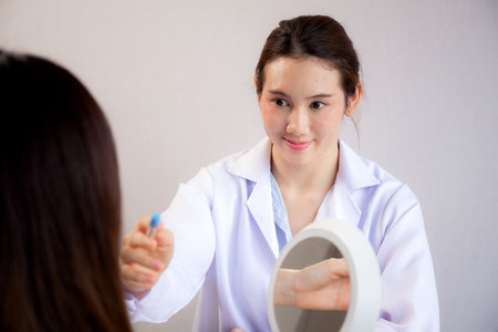 Young asian patient woman consulting with doctor in coat about wrinkle and skin for rejuvenate and beauty in modern medical office, doctor explaining and diagnostic facial of woman for cosmetology.の写真素材