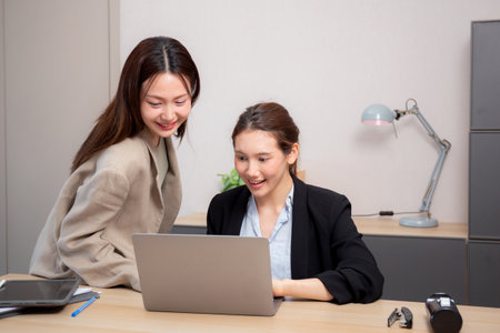 Two young business woman working together about project for success in modern office, businesswoman discussion with consulting for planning and analyzing about marketing, business and strategy.の写真素材