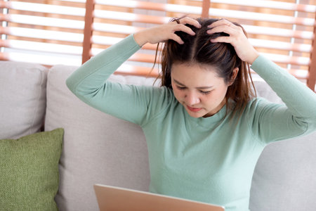 Young asian businesswoman working laptop with stress and frustrated in living room at home, business woman using on notebook with upset and tired, expression and emotion, business and lifestyle.の写真素材