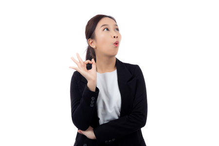 Portrait young asian business woman in suit gesture ok while surprise isolated white background, businesswoman with expression with shock, business and emotion, one person.の写真素材