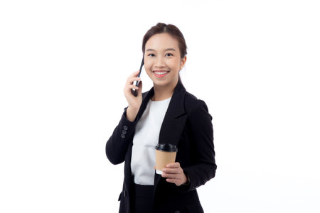Portrait cheerful young asian businesswoman holding coffee cup while talking smart phone with relax and satisfied isolated white background, business woman drinking coffee and speaking on smartphone.の写真素材