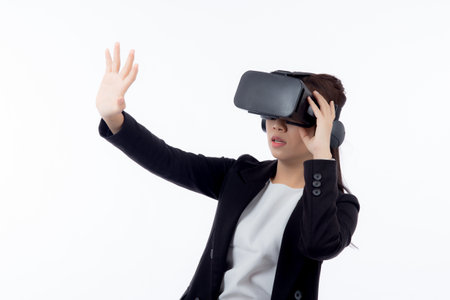 Portrait young asian businesswoman wearing headset virtual reality for device with experience and entertainment with interactive isolated white background, simulation and innovation with business.の写真素材
