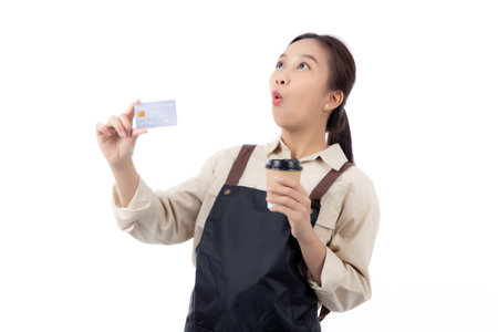 Portrait happiness young asian woman wearing apron holding credit card while shock with surprise isolated white background, barista or waitress showing debit card for purchase online, small business.の写真素材