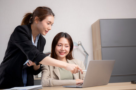 Two young business woman working together about project for success in modern office, businesswoman discussion with consulting for planning and analyzing about marketing, business and strategy.の写真素材