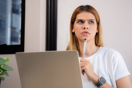 Young caucasian business woman working with laptop while thinking for planning financial on desk in modern home office, businesswoman planning and thoughtful about working, business and finance.の写真素材