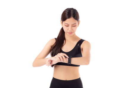 Happy young asian woman looking smartwatch for exercise and aerobics with cardio isolated on white background, female looking smart watch with wrist for pulse while workout with health, sport concept.の写真素材