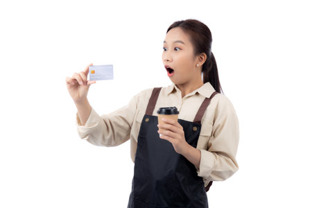 Portrait happiness young asian woman wearing apron holding credit card while shock with surprise isolated white background, barista or waitress showing debit card for purchase online, small business.の写真素材