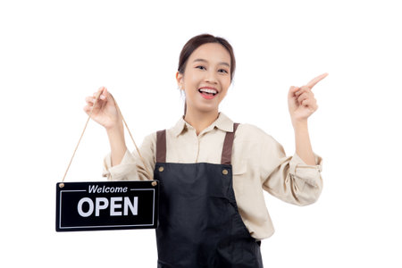 Portrait young asian barista woman wearing apron holding open sign for inviting customer to enter with happiness, waitress woman holding signboard with open, small business or startup business.の写真素材